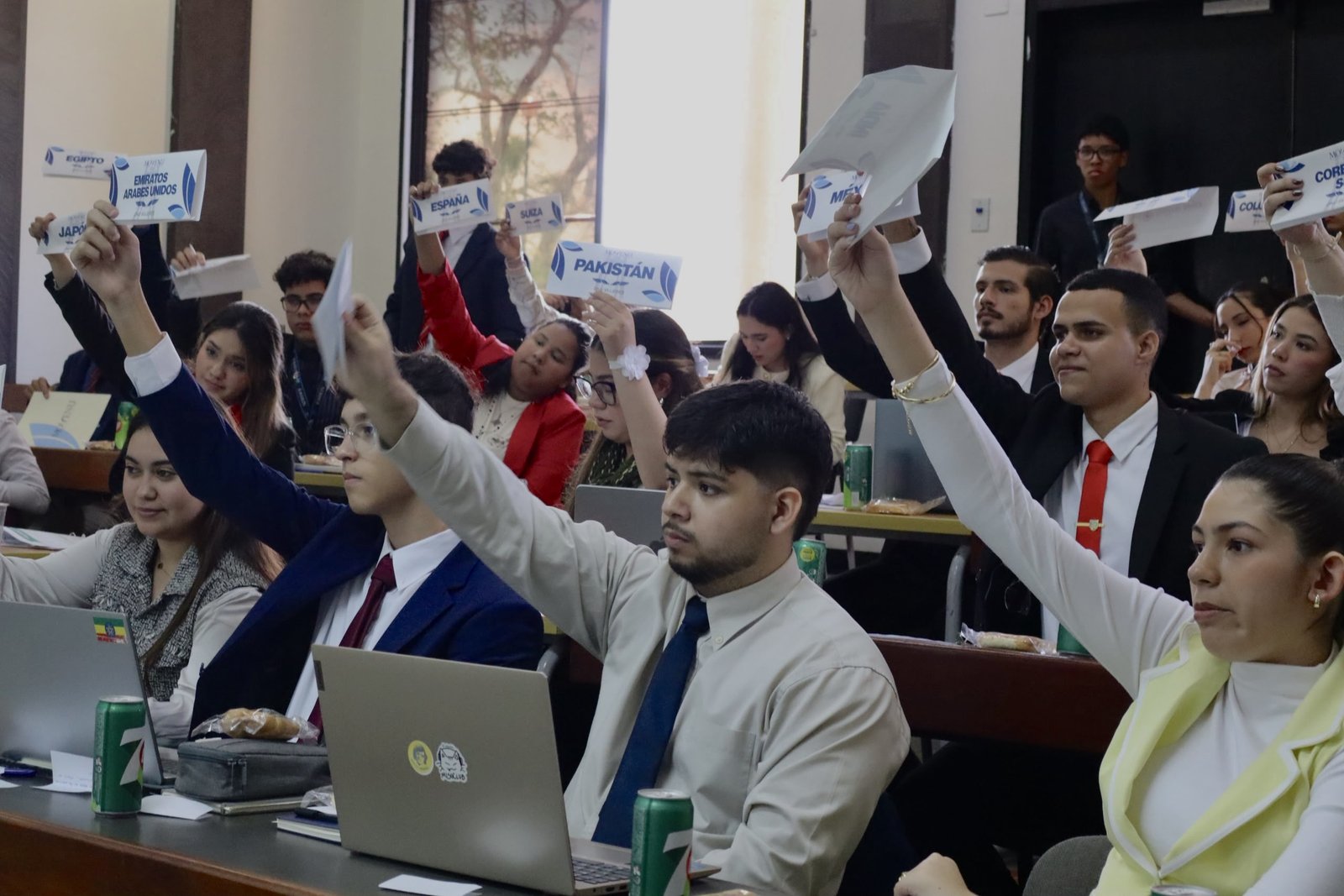 Delegados de MOVENU levantan las placas de sus países durante una votación